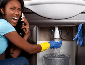 Emergency plumbing repair for a leaking sink drain under a bathroom vanity in Troy, MI