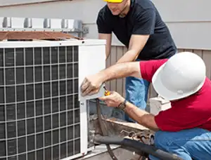 HVAC technicians repairing an outdoor AC unit on a rooftop in Troy, MI